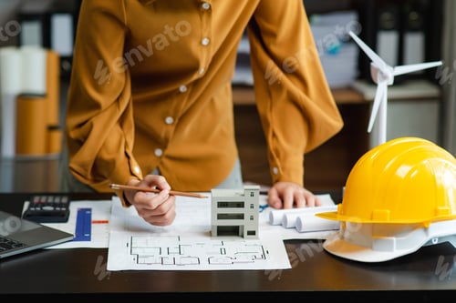 Preview: Architect planning with building model, blueprints, and safety helmet. Perfect for construction,