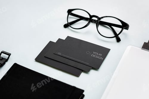 Preview: Closeup of black paper cards with eyeglasses on table