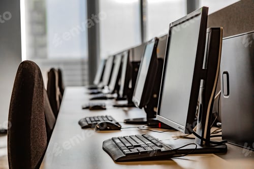 Preview: Row of computer workstations in an office with natural light coming through the windows