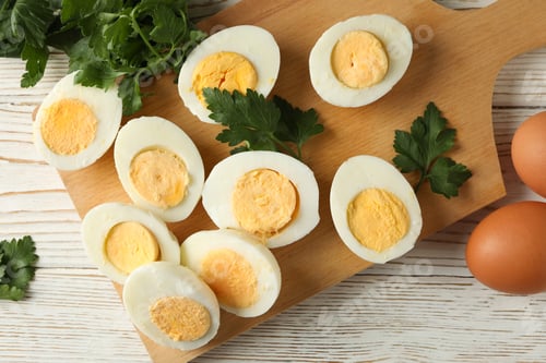 Preview: Board with boiled eggs on white wooden background
