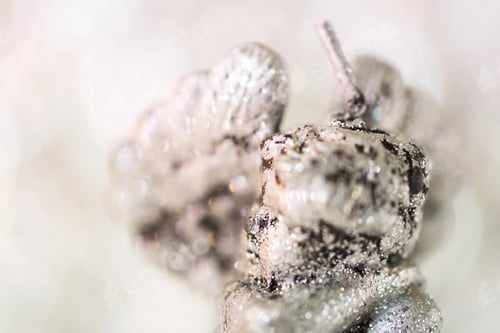 Preview: Close up of the candle with silver glitter in the shape of the angel.