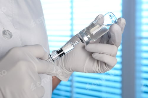 Preview: Doctor filling syringe with vaccine from vial indoors, closeup