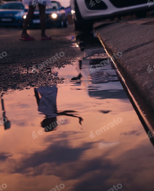 Preview: Shot of a reflection of a little kid in the street with sunset