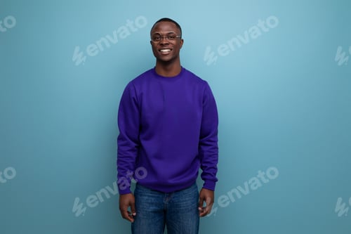 Preview: handsome young american man in blue sweatshirt on blue background with copy space