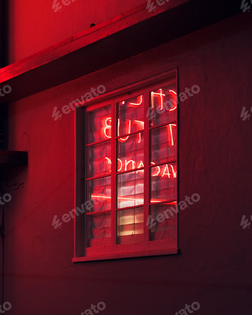 Preview: Vertical shot of words made with red led lights reflecting in the window