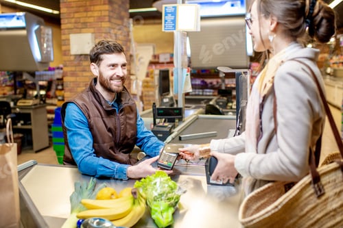 Preview: Woman with happy cashier at the cash register