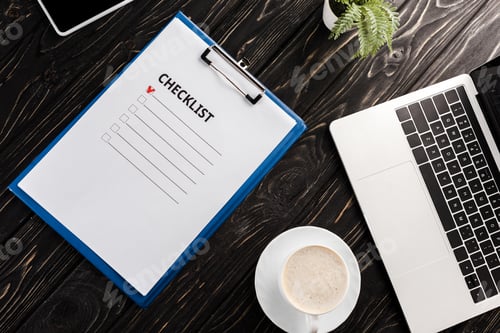 Preview: top view of clipboard with checklist letters near laptop, plant and cup of coffee on table,