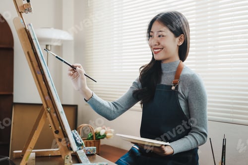 Preview: Female artist painting on canvas with brush Young painter working on the floor of her art studio cre