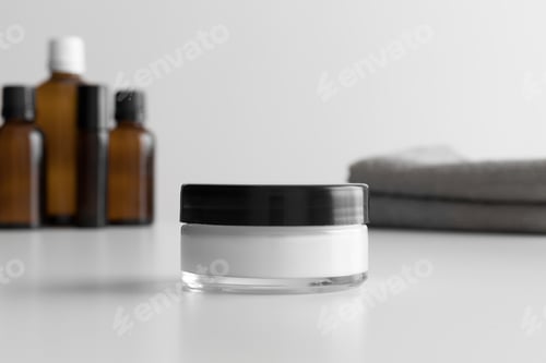 Preview: Cream Jar and Cosmetic Bottles on a White Surface