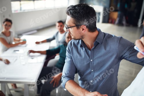 Preview: Shot of a mature man writing on a whiteboard while giving a presentation to colleagues in an office
