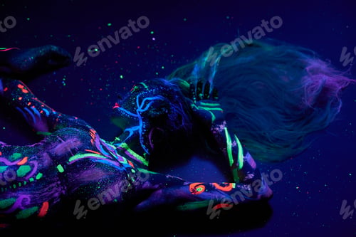 Preview: Art woman body dancing in ultraviolet light. Bright abstract drawings girl body neon color. Fashion