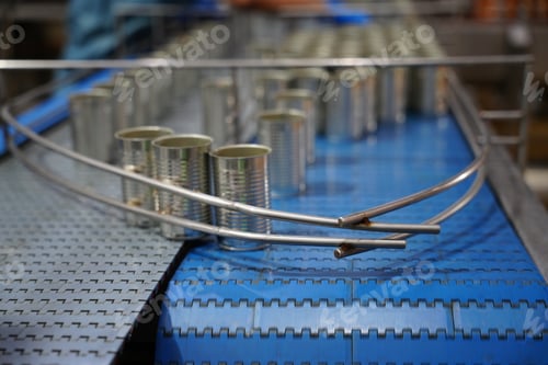 Vista previa: Cans moving along a conveyor belt in a food processing facility during production
