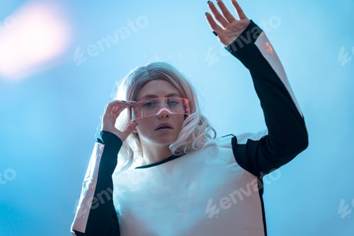 Preview: Beautiful woman with the futuristic glasses, blue background, future and virtual reality concept