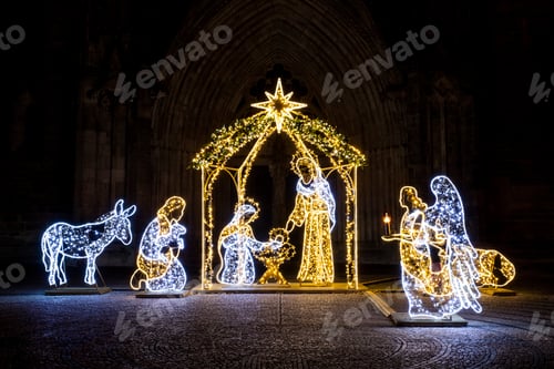 Preview: Christmas Manger scene art made many led bright garland lit lamps against old ancient Magdeburg Dom
