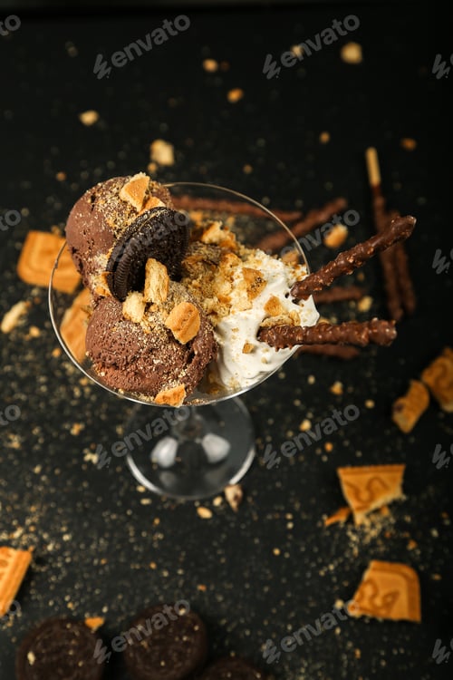 Preview: top view chocolate chip cookies with whipped cream and chocolate sticks in glass on black background