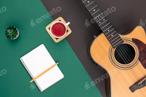 Preview: Flat lay, acoustic guitar and notebook on color background.