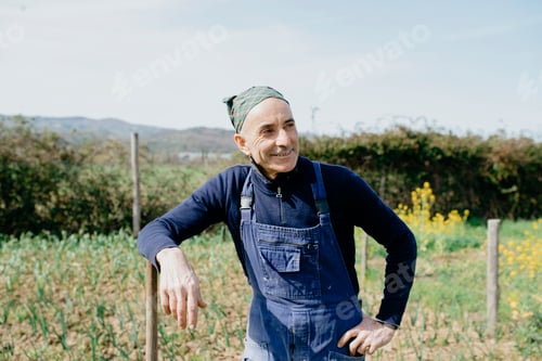 Preview: Smiling man in overalls enjoying a sunny day on the farm