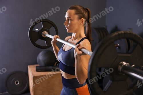 Preview: Sportswoman with barbell during workout in gym