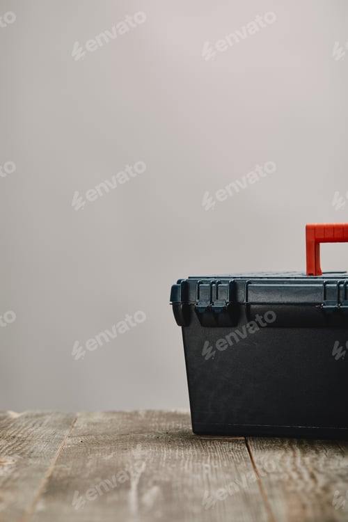 Preview: Close up of tools box on wooden table on grey background