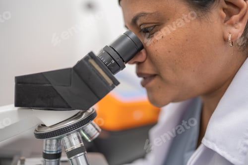 Preview: Lab technician observing and analyzing cells under the laboratory microscope