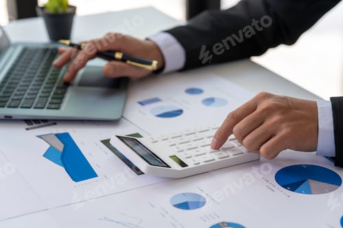 Preview: businessmen or accountants using a calculator calculates and laptop computer while working analytic
