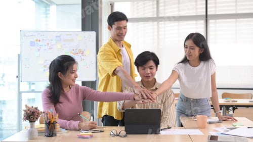 Preview: Startup business people are stacking hands over table, showing group unity, celebrating successful.