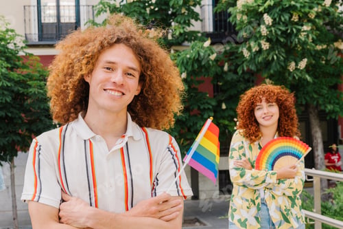 Preview: Joyful couple waving rainbow flag, embodying lgbtq+ pride and unity at urban pride celebration