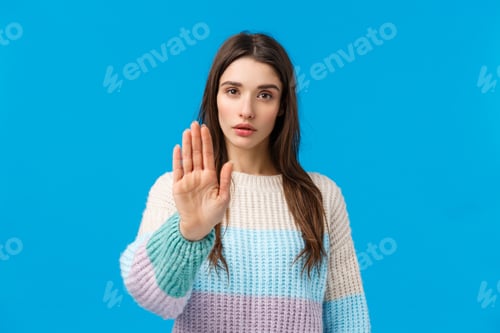 Preview: Please stop. Serious-looking assertive and confident young attractive woman pulling hand forward in