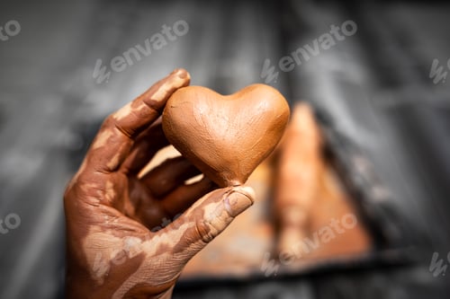 Preview: Heart made of potter's clay in the hands of a master potter