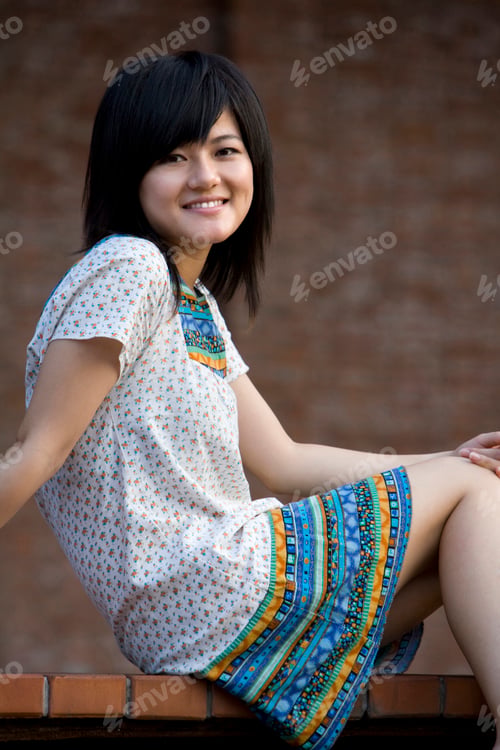Preview: Young woman sitting on ground