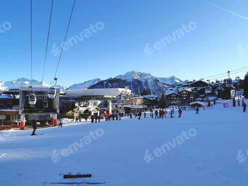 Preview: Ski resort in winter. The lift station. There are a lot of skiers and snowboarders on the slope.