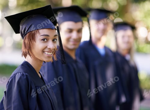 Preview: A group of smiling graduates standing in a row and looking at the camera