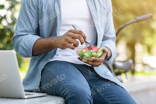 Preview: Unrecognizable African Man Eating Salad, Having Healthy Lunch Outdoors In Park