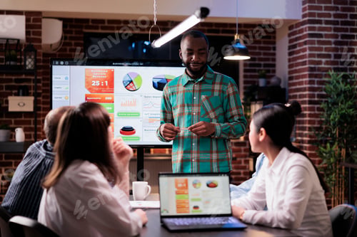 Preview: African american coworker talking with diverse team brainstorming marketing ideas in late night
