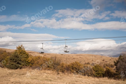 Preview: empty two ropeway chairs of mountain ski resort in autumn