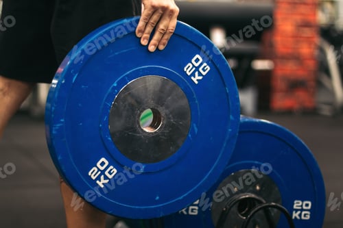 Preview: man taking a weight plate in a gym