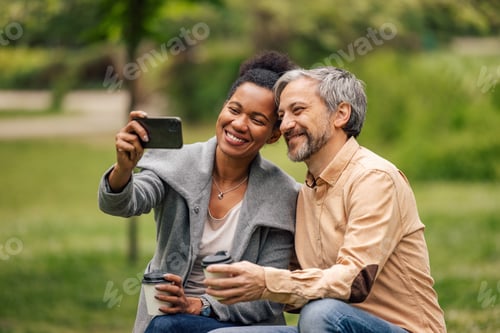 Preview: People sitting in the park, smiling face, taking photos with phone.