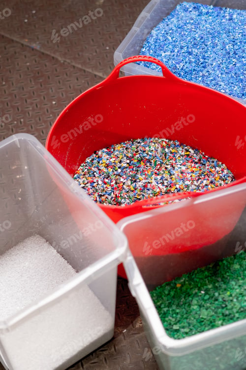 Preview: Close-up shot of shredded plastic caps stored in a special container at waste recycling station