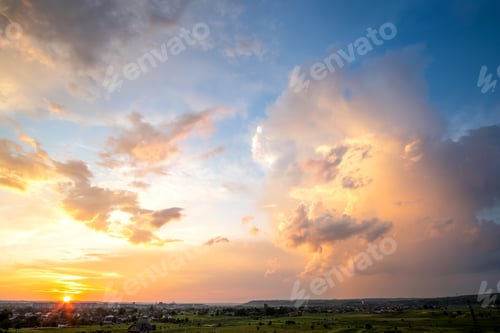 Preview: Dramatic sunset landscape of rural area with stormy puffy clouds