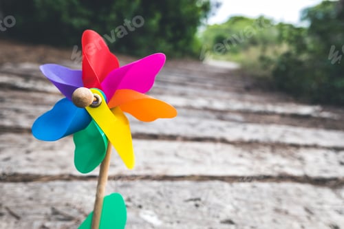 Preview: Children's toy pinwheel on a path in a forest, concept of good direction with copy space.