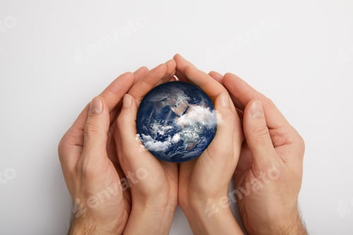 Preview: top view of man and woman holding planet model on grey background, earth day concept