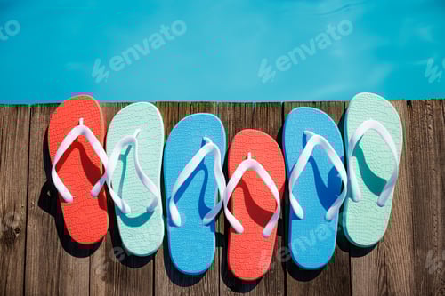 Preview: Beach flip-flops on wooden planks near swimming pool