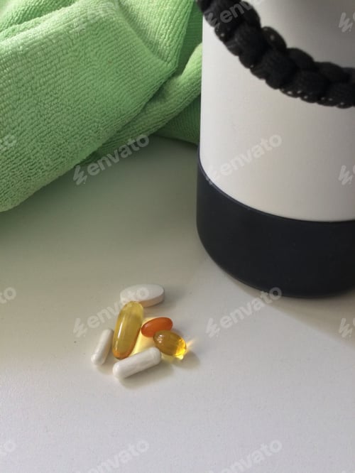 Preview: A Green Yoga Towel and a Small Pile of Vitamins on a White Counter