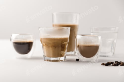 Preview: Glasses with assorted coffee drinks on white background with coffee beans