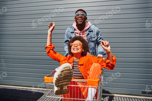 Preview: Cheerful young african american best friends in sunglasses and bright outfits having fun