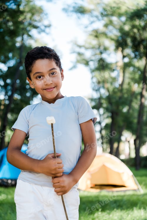 Preview: happy african american boy holding stick with sweet marshmallow