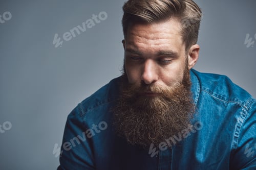 Preview: Young man with a long beard deep in thought