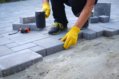 Preview: The master in yellow gloves lays paving stones