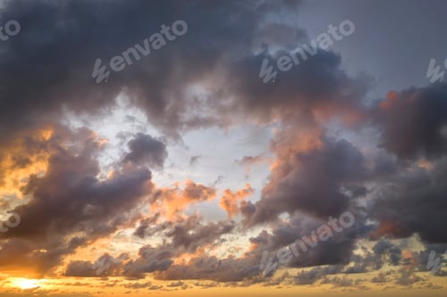 Preview: Colofrul clouds brightly illuninated by setting sun on evening sky.