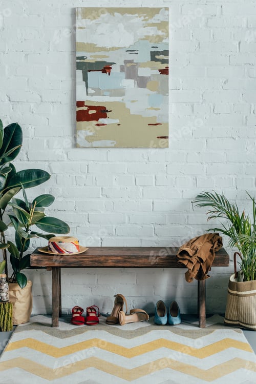 Preview: different shoes under wooden bench in corridor at home, painting on wall